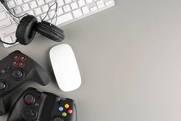 Gamepads, mouse e fones de ouvido em fundo cinza — Fotografia de Stock