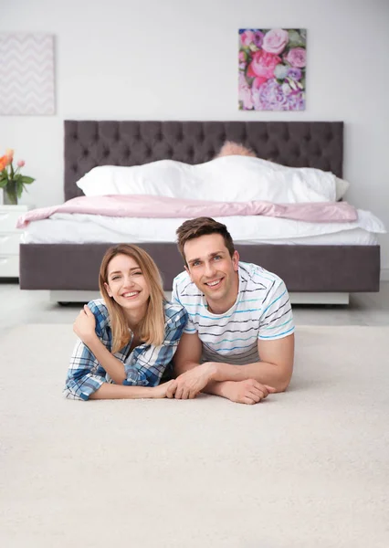 Schönes junges Paar liegt zu Hause auf kuscheligem Teppich — Stockfoto