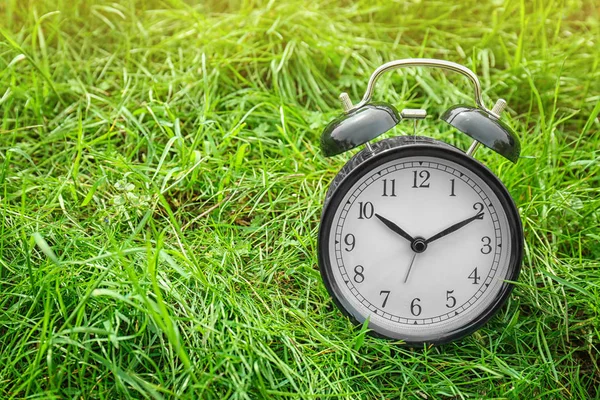 푸른 잔디, 야외에 알람 시계입니다. 시간 변화 개념 — 스톡 사진