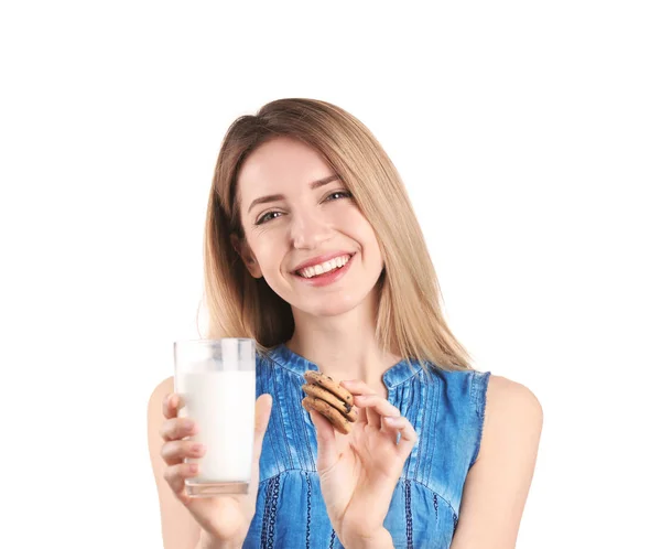 Bella giovane donna che beve latte con biscotti su sfondo bianco — Foto Stock