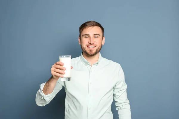 Joven con vaso de sabrosa leche sobre fondo de color — Foto de Stock