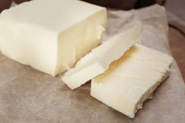 Sabrosa mantequilla fresca cortada en pergamino, primer plano — Foto de Stock