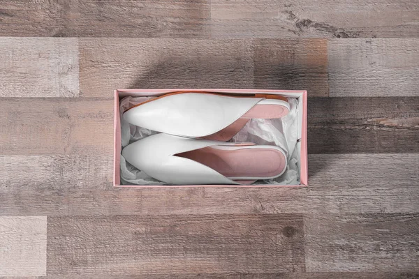 Coppia di scarpe femminili in scatola su sfondo in legno, vista dall'alto — Foto Stock