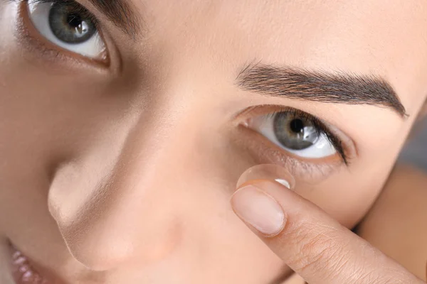 Mladá žena uvedení kontaktní čočky v oku, closeup — Stock fotografie