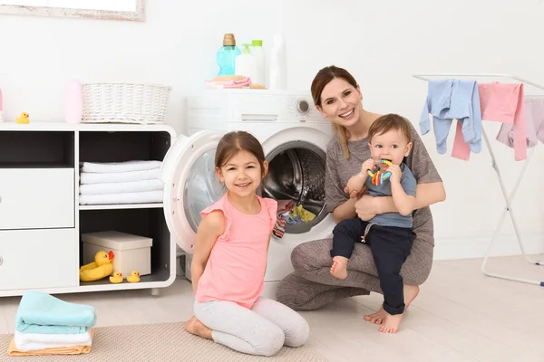 Huisvrouw met kleine kinderen doen Wasserij thuis — Stockfoto