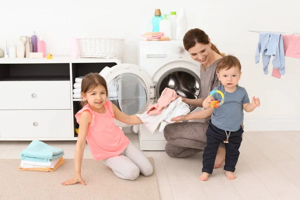 Gospodyni domowa z małymi dziećmi w domu pranie. — Zdjęcie stockowe