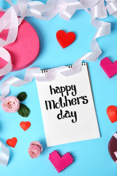 Notebook with phrase "HAPPY MOTHER'S DAY" and decor on color background — Stock Photo, Image