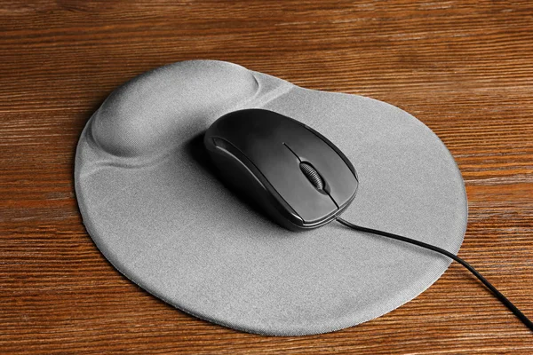 Blank pad and computer mouse on wooden background