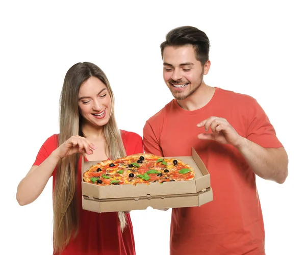 Casal jovem atraente com deliciosa pizza no fundo branco — Fotografia de Stock