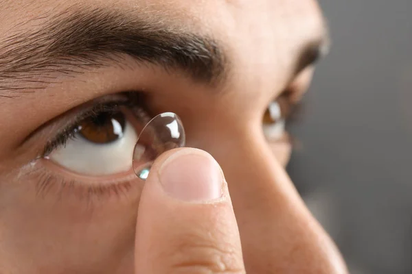 Jovem colocando lente de contato em seu olho, close-up — Fotografia de Stock