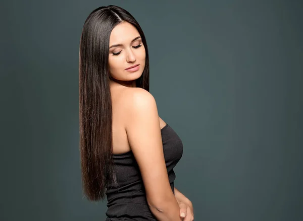 Portret van mooie model met prachtige rechte haren op kleur achtergrond — Stockfoto