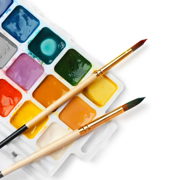 Paleta de plástico com tintas e pincéis coloridos sobre fundo branco, vista superior — Fotografia de Stock