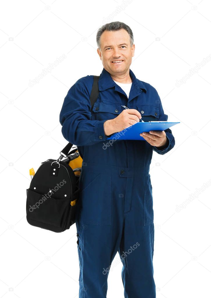 Mature plumber with clipboard and tool bag on white background