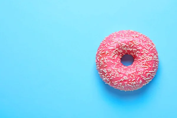 Köstliche glasierte Donut mit Streusel auf Farbhintergrund, Draufsicht — Stockfoto