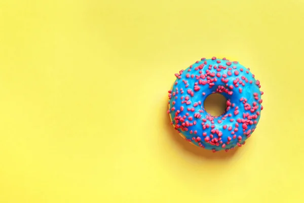 Köstliche glasierte Donut mit Streusel auf Farbhintergrund, Draufsicht — Stockfoto