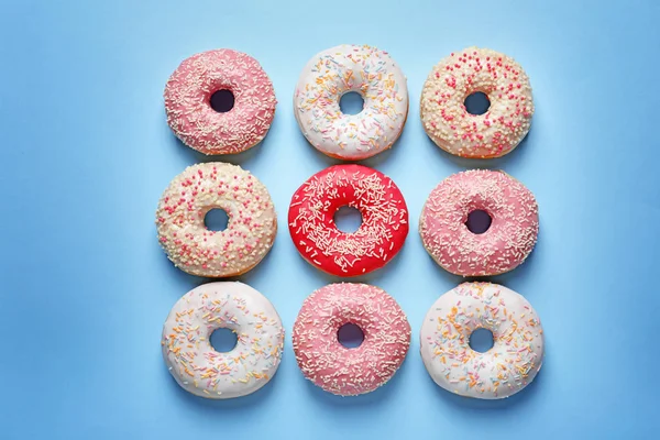 Deliciosos donuts envidraçados no fundo da cor, vista superior — Fotografia de Stock