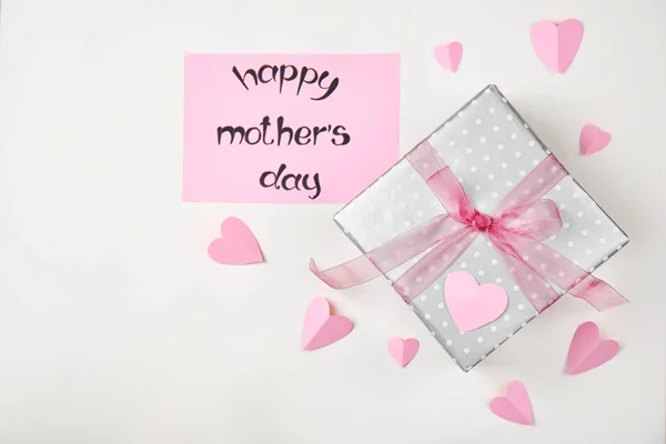 Compoziție așezată plat cu inimi de hârtie și cutie de cadouri elegantă pentru Ziua Mamei pe fundal luminos — Fotografie, imagine de stoc
