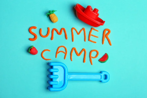 Flache Liegekomposition mit Wörtern Sommerlager aus Modelliermasse und Strandspielzeug auf farbigem Hintergrund — Stockfoto