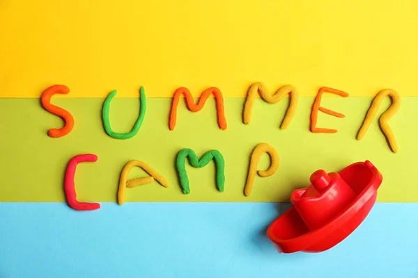 Wörter Sommerlager aus Modelliermasse und Plastikboot auf farbigem Hintergrund, Draufsicht — Stockfoto