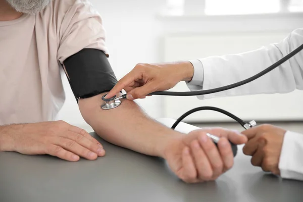 Médico midiendo la presión arterial del paciente en el hospital — Foto de Stock