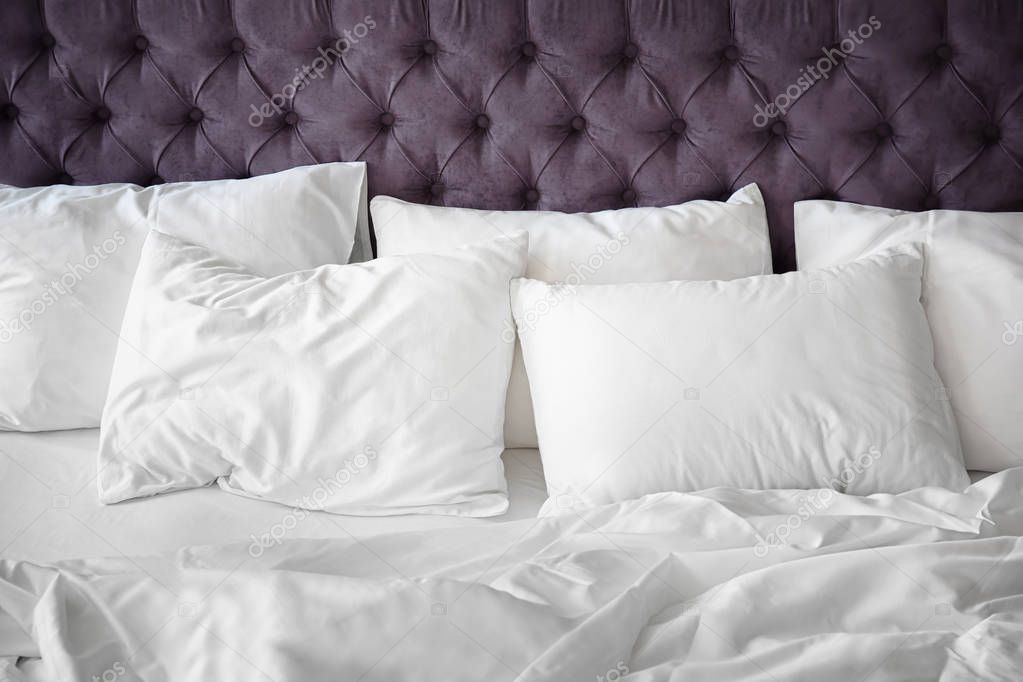 Comfortable bed with white linen at home