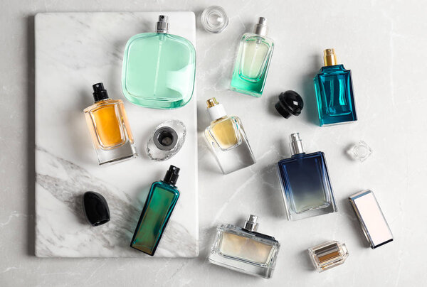 Perfume bottles on light background, flat lay