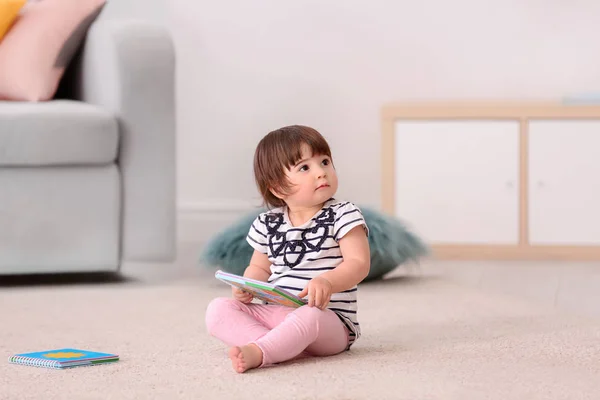Niedliche Baby Mädchen Mit Buch Sitzt Auf Dem Boden Hause — Stockfoto