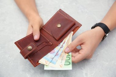 Avro banknotlarını cüzdana koyan adam, yakın plan.