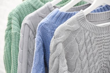 Kalın kazak koleksiyonu askıda asılı, yakın plan.