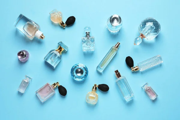 Composizione flat lay con diverse bottiglie di profumo su sfondo azzurro — Foto Stock