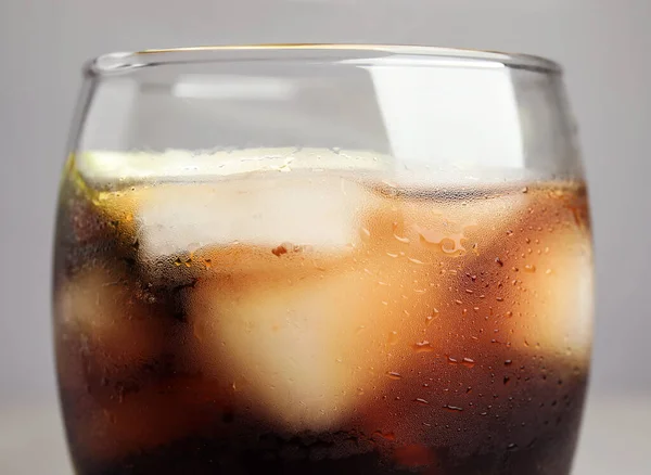 Стакан освежающего напитка с кубиками льда на сером фоне, крупным планом — стоковое фото
