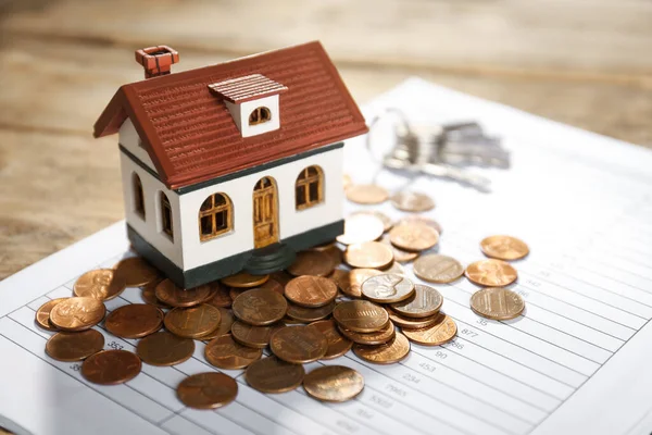 Modelo de casa com moedas e documento na mesa, close up. Serviço de agente imobiliário — Fotografia de Stock