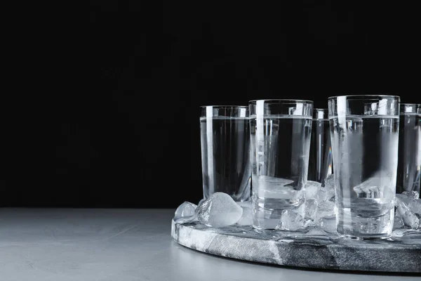 Vodka en vasos de chupito y hielo sobre mesa gris. Espacio para texto —  Fotos de Stock