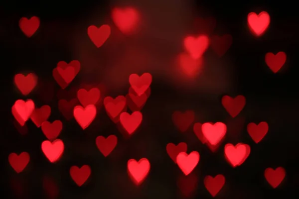 Vue floue des lumières rouges en forme de coeur sur fond noir — Photo