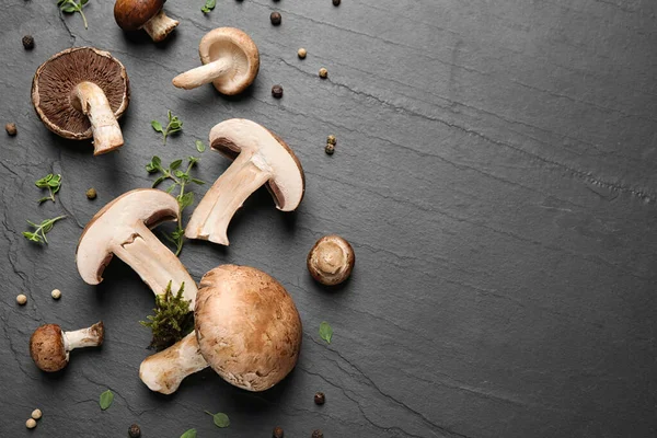 Flat lay composition with fresh wild mushrooms on black table, space for text — Stock Photo, Image