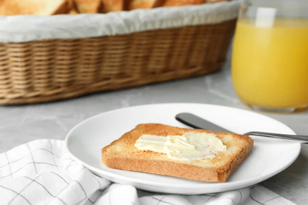 Fatia de pão torrado com manteiga na mesa cinzenta — Fotografia de Stock