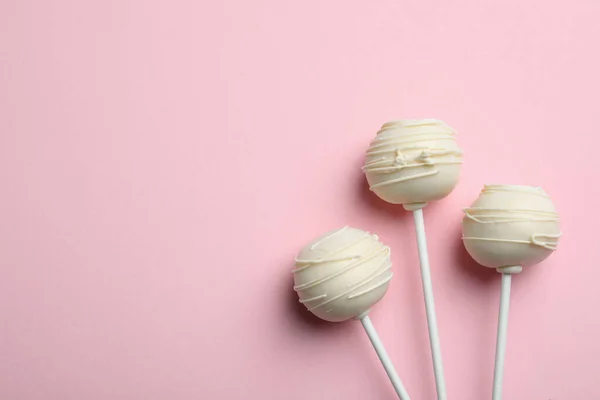Sweet cake pops on pink background, flat lay. Space for text