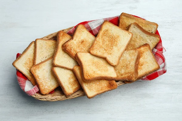 흰 나무 식탁에 구운 빵을 얹은 바구니, 맨 위에 보이는 것 — 스톡 사진