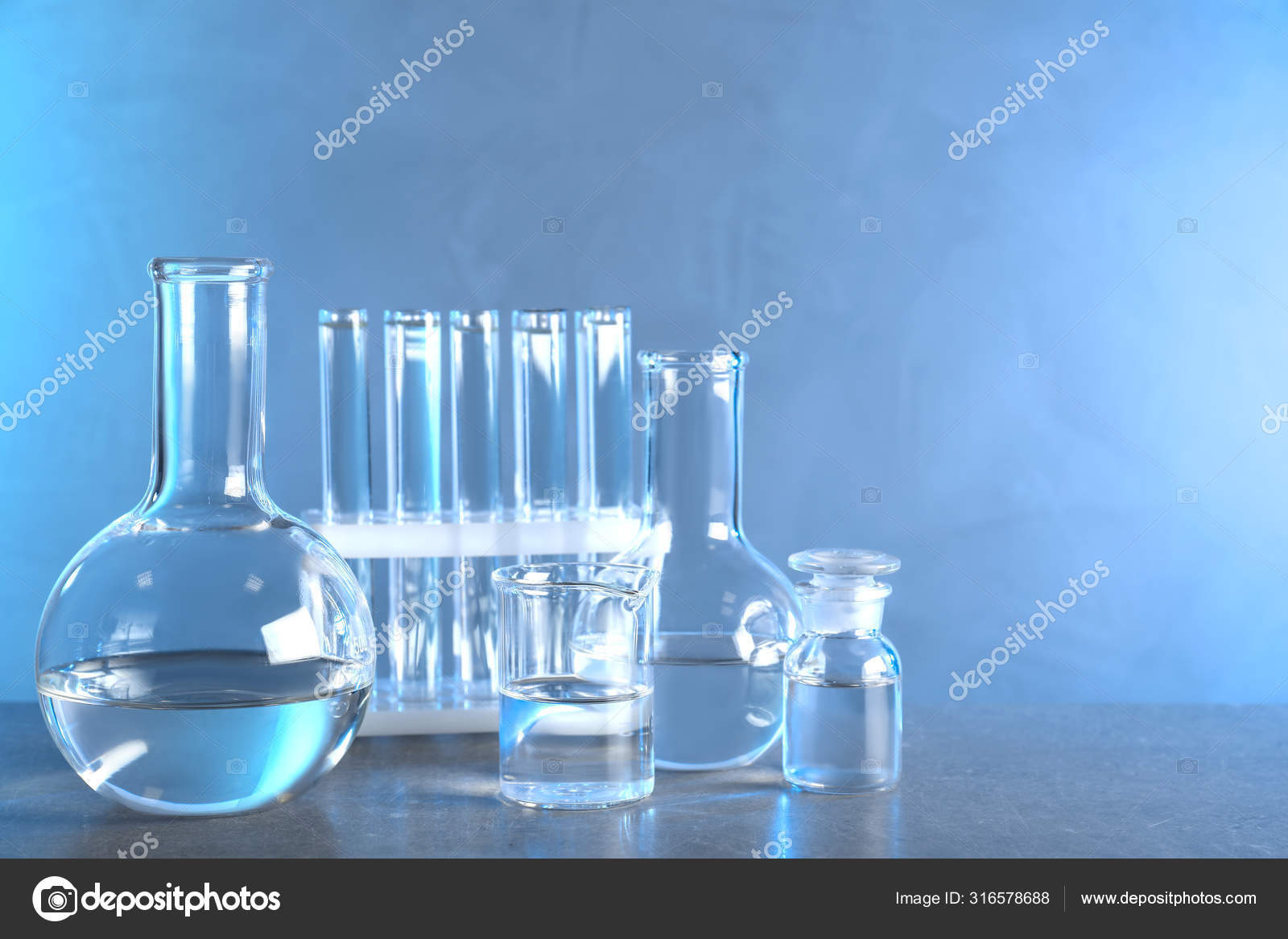 Laboratory glassware with liquid samples for analysis on grey table