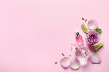 Pembe arka planda zarif parfümlü düz konum, metin için boşluk