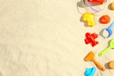 Kum üzerinde plastik plaj oyuncakları ile Düz yatıyordu kompozisyon. Metin için alan