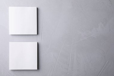 Açık gri arkaplan üzerine boş not kağıtları, düz yatış. Tasarım için hazırlan