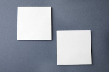 Koyu gri arkaplan üzerine boş not kağıtları, düz yatış. Tasarım için hazırlan