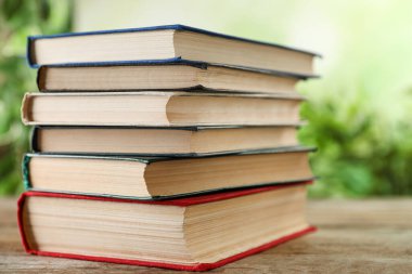 Bulanık arka plana karşı ahşap masadaki ciltli kitap yığını