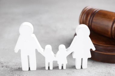 İnsan şeklinde bir figür ve gri masadaki tahta tokmak. Aile hukuku kavramı