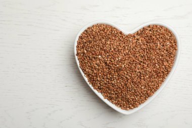 Beyaz ahşap masa üzerinde karabuğday taneleri, üst manzara. Metin için boşluk