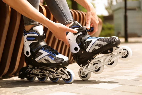 Femme portant des patins à roulettes modernes en ligne dans le parc de la ville, gros plan — Photo