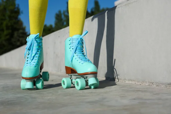 Young woman with retro roller skates in city on sunny day, closeup — Stock Photo, Image