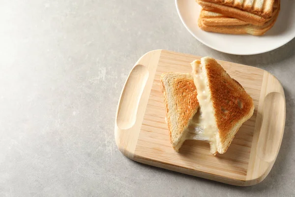 Plateau en bois avec sandwichs au fromage frais sur table grise, vue ci-dessus. Espace pour le texte — Photo