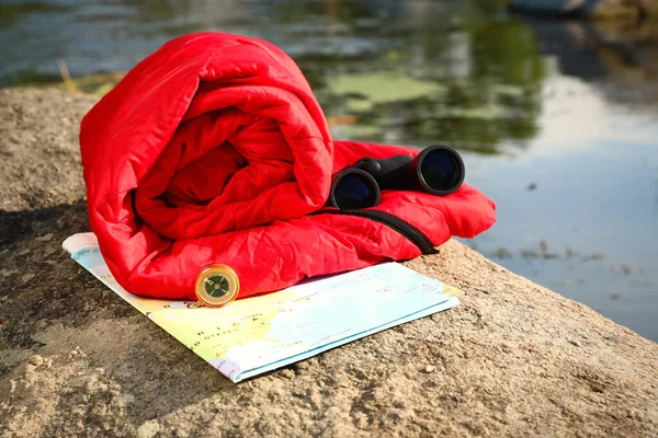 Rullade sovsäck och annan campingutrustning utomhus på solig dag — Stockfoto